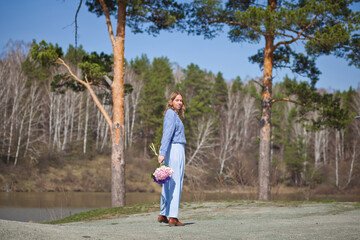 girl with a bouquet of hydrangeas walks on the shore, spring photo session
