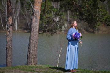 girl with a bouquet of hydrangeas walks on the shore, spring photo session