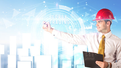 Handsome businessman with helmet drawing FOREX TRADING inscription, contruction business concept