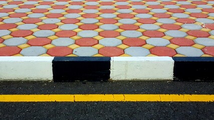 hexagonal tiled mosaic path with contrasting black and white painted safety curb edging