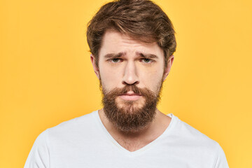 Obraz premium Man in white t-shirt emotions studio gestures with hands displeased facial expression yellow background