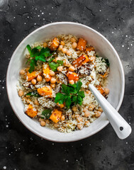 Autumn vegetarian lunch - couscous with fried pumpkin and eggplant on a dark background, top view