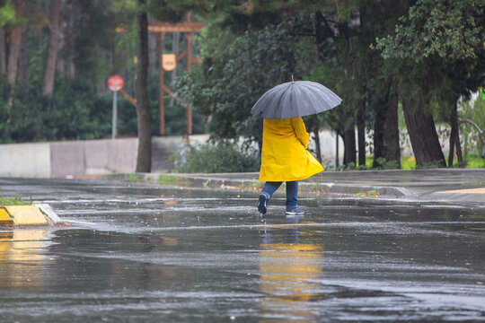 Man in yellow raincoat walking on a rainy day