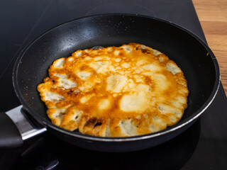 Sweet crepes frying in pan