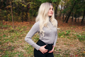 Close up portrait of pretty blonde woman wearing trendy casual outfit