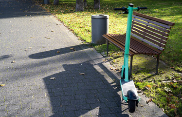 hulajnoga zaparkowana przy ławce w parku