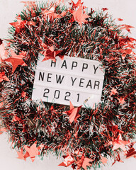 Red and green wide cut christmas tinsel garland. New year 2021 lettering in the center. Close up. Christmas mood. 