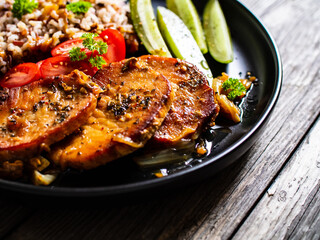 Roasted meat, buckwheat and pickled cucumbers on wooden table
