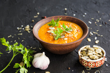Delicious healthy pumpkin soup, herbs, and ingredients for the dish. Creative atmospheric decoration