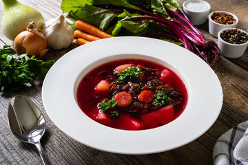 Borsch - beetroots soup with cream on wooden table

