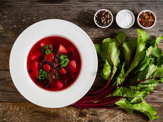 Borsch - beetroots soup with cream on wooden table
