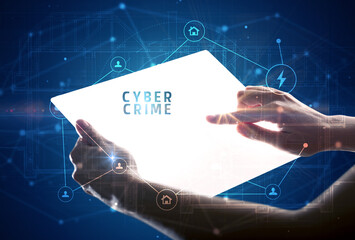 Holding futuristic tablet with CYBER CRIME inscription, cyber security concept