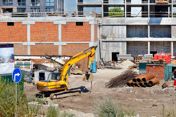 A heavy crawler construction excavator works at a construction site.