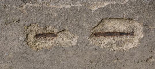 Broken, chipped grey concrete background with rust patches and cracks