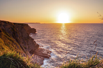 Landscape of sea with montains, dramatic wave and rock in sunset.