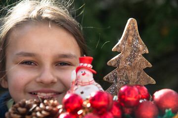 Close-up of a smiling girl's face and front Christmas decorations