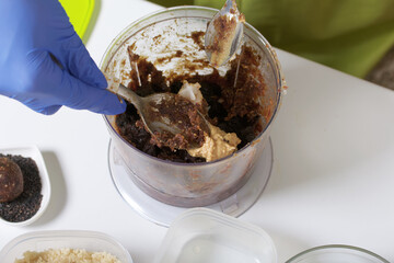 Chopped dates and peanut butter in a blender bowl. For making sweets at home in self-isolation during an epidemic. Close-up shot.