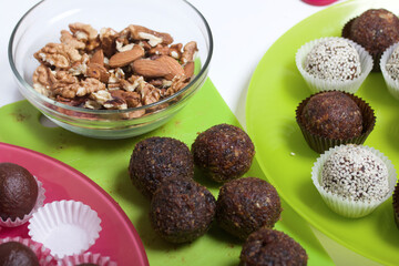 Dried fruit and nut sweets. Some are sprinkled with sesame seeds. Made at home in self-isolation during the epidemic. They lie in paper capsules.