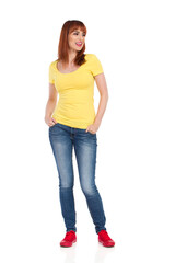 Happy Casual Young Woman Is Standing With Hands In Pockets, Looking Away And Talking