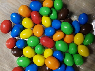 Multicolored chocolate-covered nuts in a transparent plate
