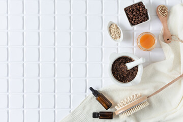 Homemade body scrub made with ground coffee, honey and oatmeal in a jar on white table.