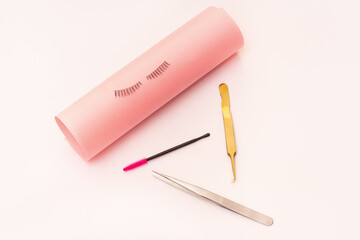 Eyelash extension tools and artificial eyelashes on white background