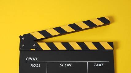 Naklejka premium Clapper board or movie slate. it use in video production and cinema industry on yellow background.