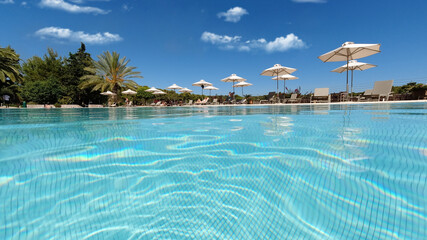 Underwater split photo of paradise turquoise pool as seen in exotic resort