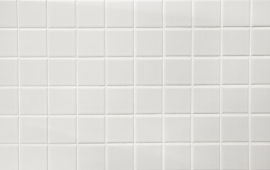 White ceramic squares with white filler on bathroom wall. Background.