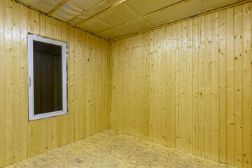 Fragment of a room, finished with wooden clapboard, with a window