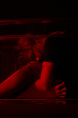 Horrible portrait of a young girl in a horror room with a red light.