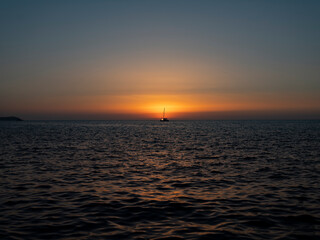 ship crosses the sea in the sunset