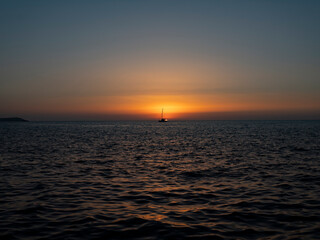 ship crosses the sea in the sunset