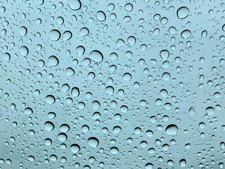 Rainwater beading up on the windshield of an automobile.