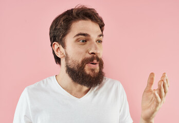 Portrait of a man with a beard and mustache on a pink background close-up cropped view