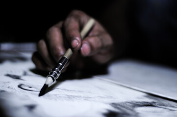 charcoal in the hand of a drawing artist