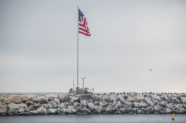 Birds skim across water at breakwater