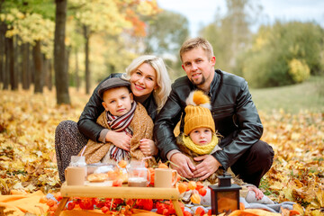 Family at picnic in the park.hot cocoa, croissants, yellow dry flowers. leaf fall, lifestyle.