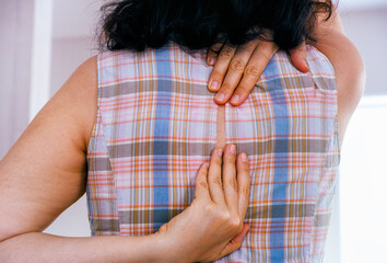 Woman hands touching ripped hole in back of her dress