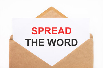 A white sheet with the text spread the word lies in an open craft envelope on a white background with copy space. Business concept image
