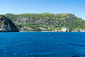 The green hills towering over Palaiokastritsa resort in Corfu, Greece, as seen from a boat