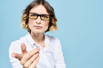 Business woman in a light shirt on a blue background gestures with her hands emotions model work