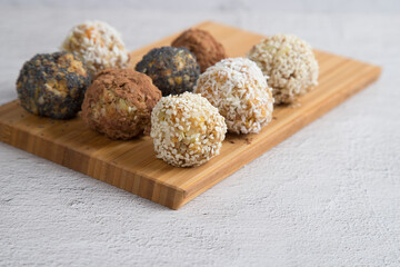 Homemade energy balls with dried fruits , nuts, sesame seeds, cocoa, almonds and poppy seeds . Vegan and vegetarian raw appetizer or food. Close-up, copy of the space.