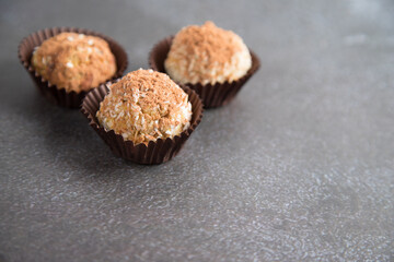 Homemade energy balls made from dried fruits, nuts, granola, sprinkled with cocoa in baking molds . Vegan food. Close-up, copy space