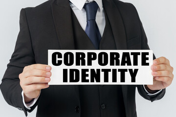 A businessman holds a sign in his hands which says - CORPORATE IDENTITY