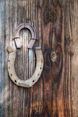 Two horseshoes nailed onto rustic wooden door as a lucky charm