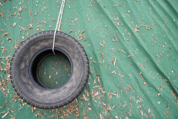 Discarded tire on a dirty greeb background, with copy space