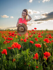Young girl in a red dress in a poppy field
