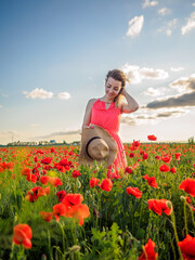 Young girl in a red dress in a poppy field
