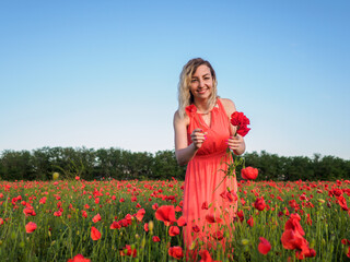 Young girl in a red dress in a poppy field

